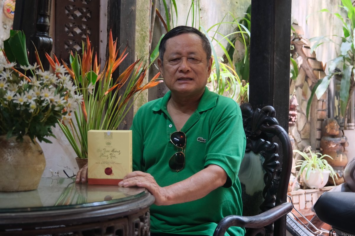 Khách nam áo xanh bên hộp Thần Hương
