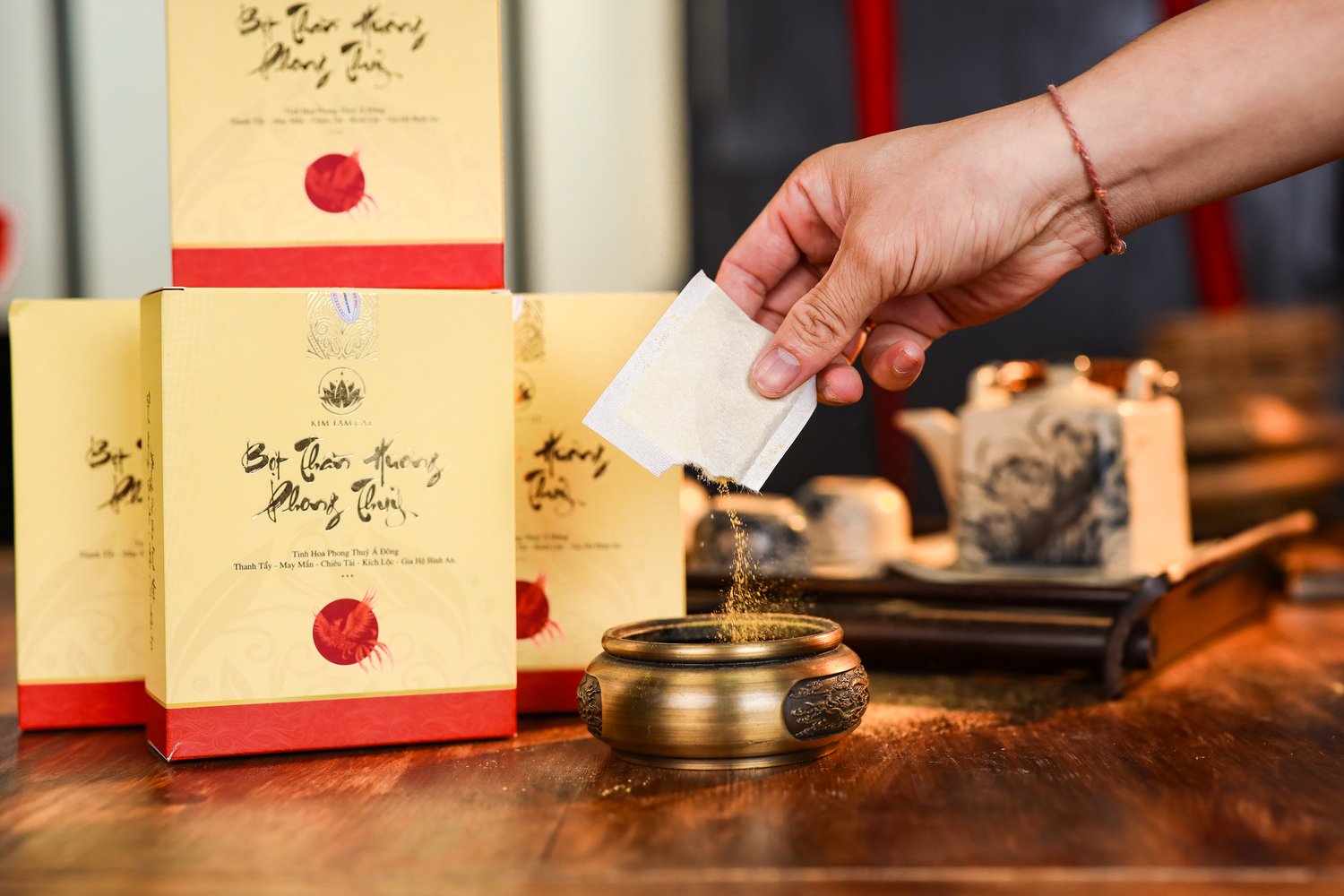 Tay đang đổ một túi bột Thần Hương vào lư xông bằng đồng