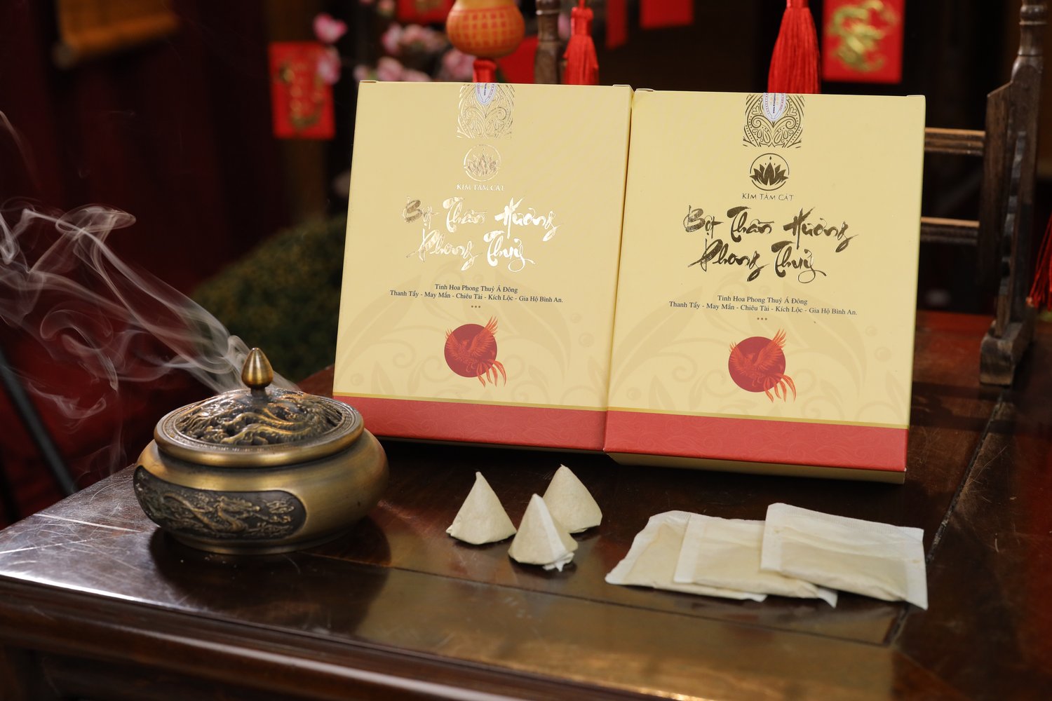 Lư đồng đang bốc khói bên hai hộp Thần Hương mở nắp, nụ và túi bột trên bàn gỗ